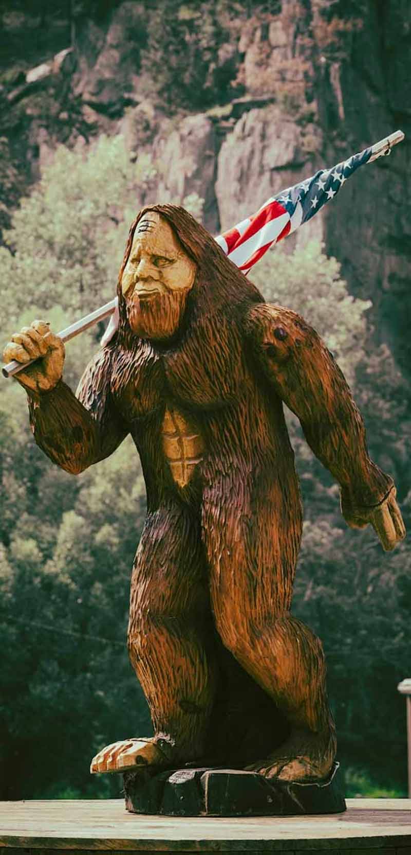 Bigfoot statue holding American flag